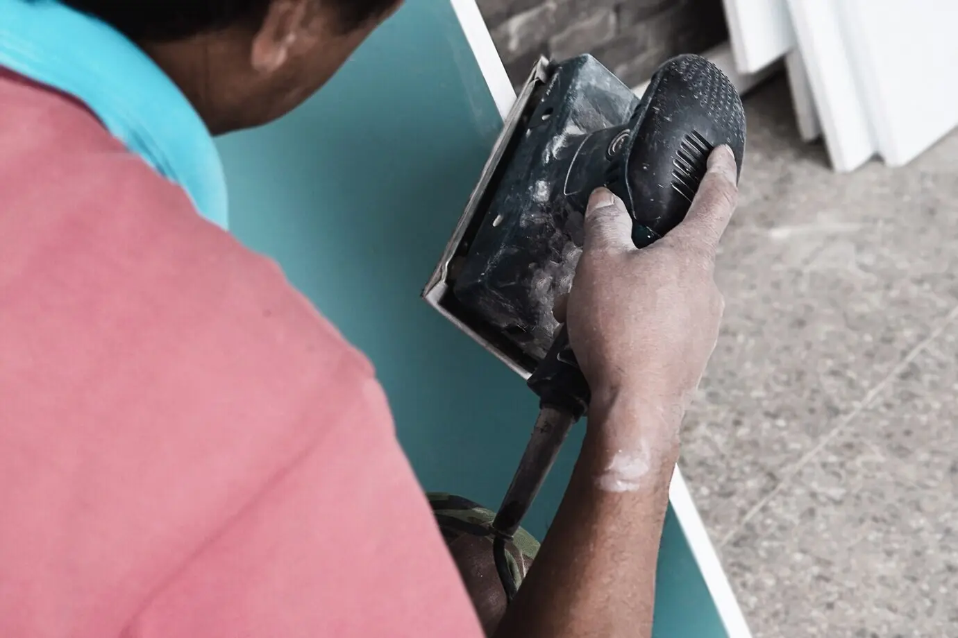 A painter is engaged in the furniture painting process using a scrub machine.
