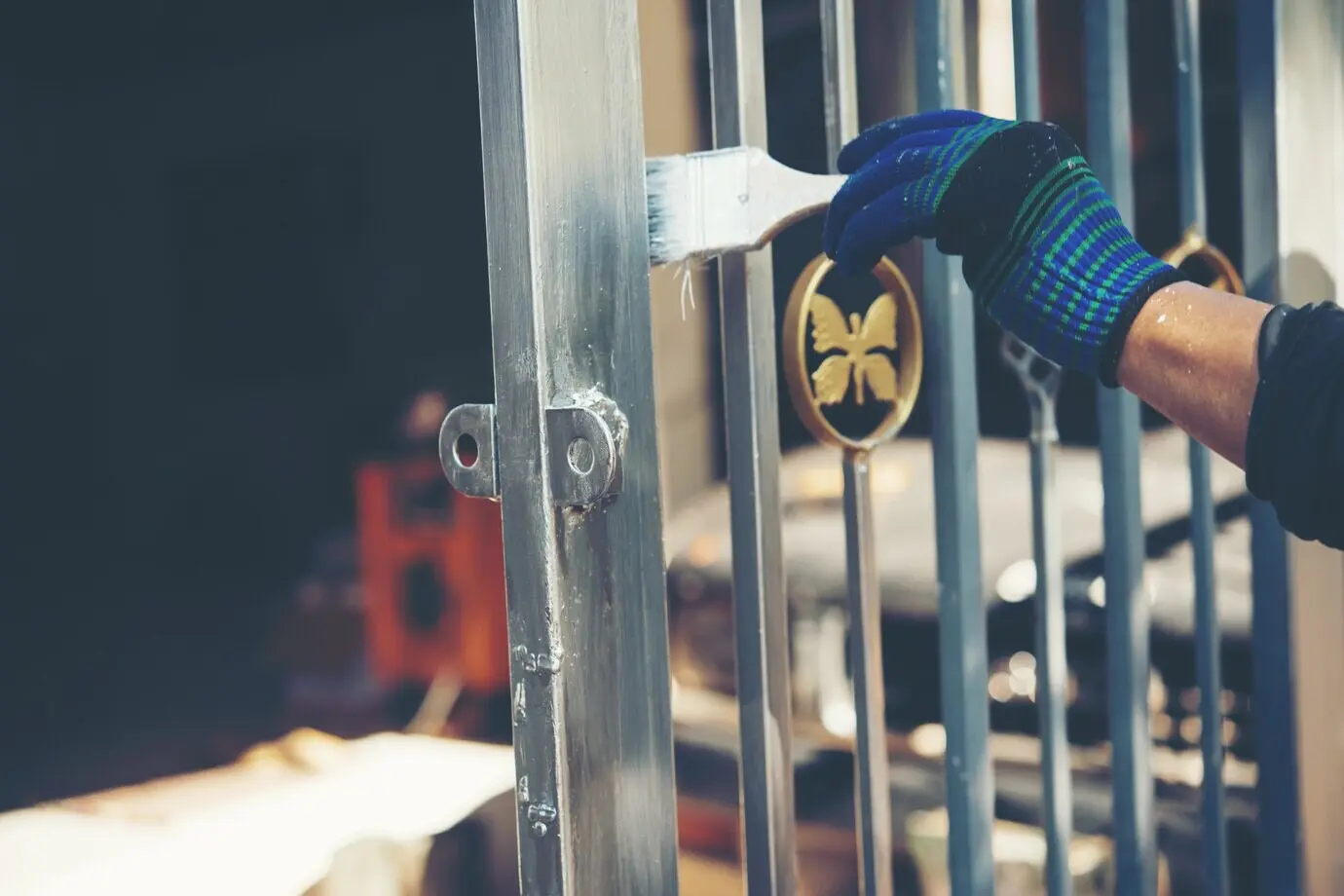 A construction worker is painting a fence at home.